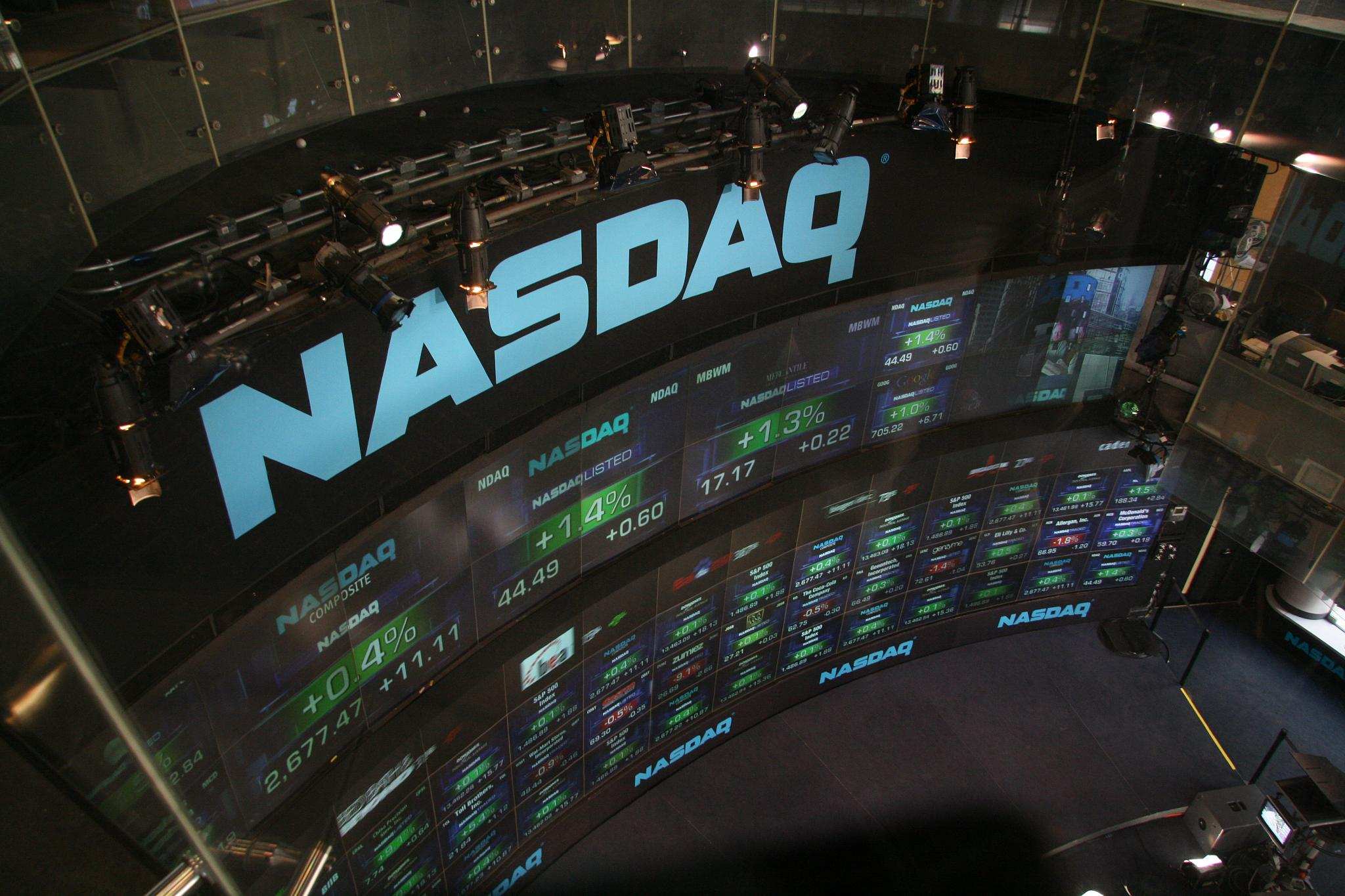 Nahaufnahme einer NASDAQ-Börsendisplay-Wand mit laufenden Kursdaten und Marktinformationen